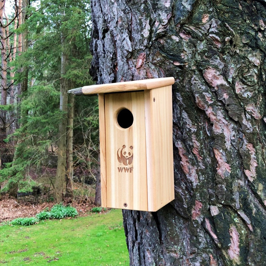 Cedar birdhouse with WWF logo on a tree